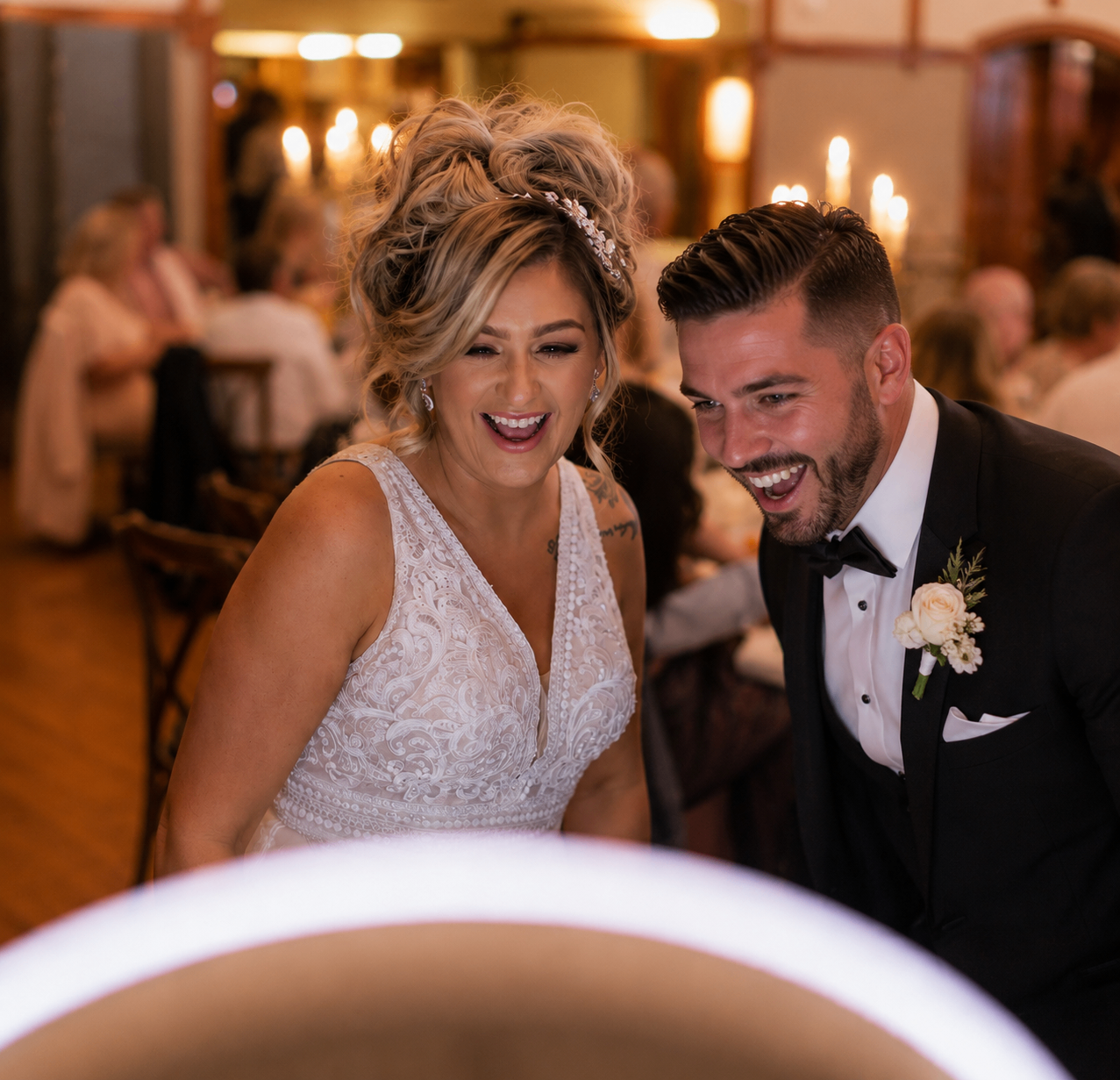 Bride and groom smiling at the selfie booth screen