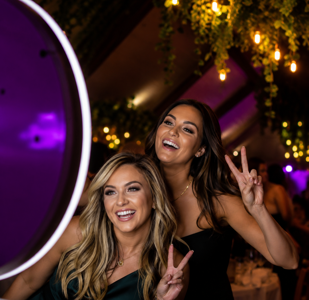Friends throwing peace signs at the ring-light selfie booth